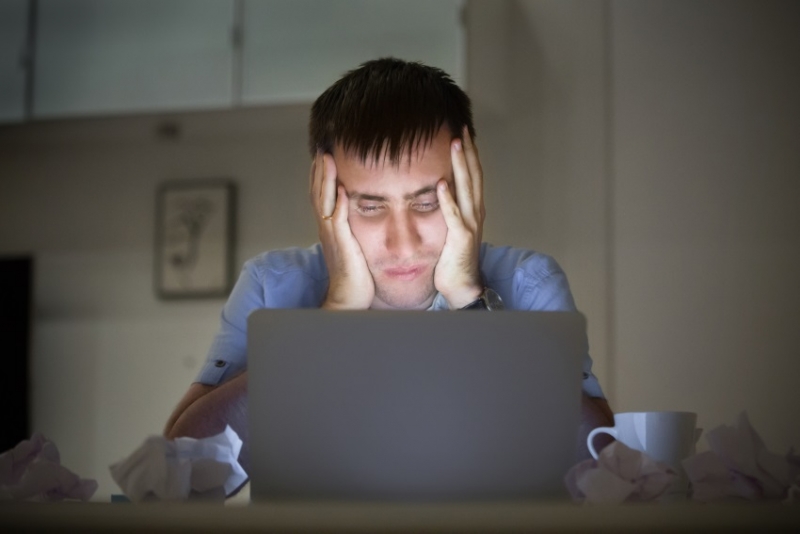 Tired man looking at his computer